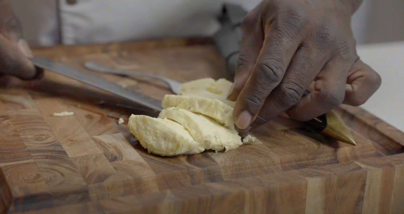 Close up of a person cutting cooked OvaEasy eggs with a knife.