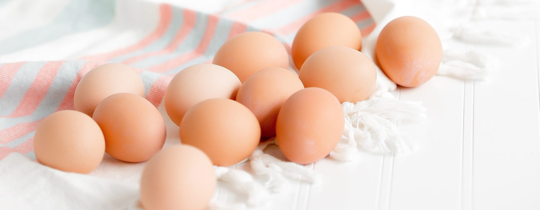 Eggs on a blue and pink striped tablecloth.